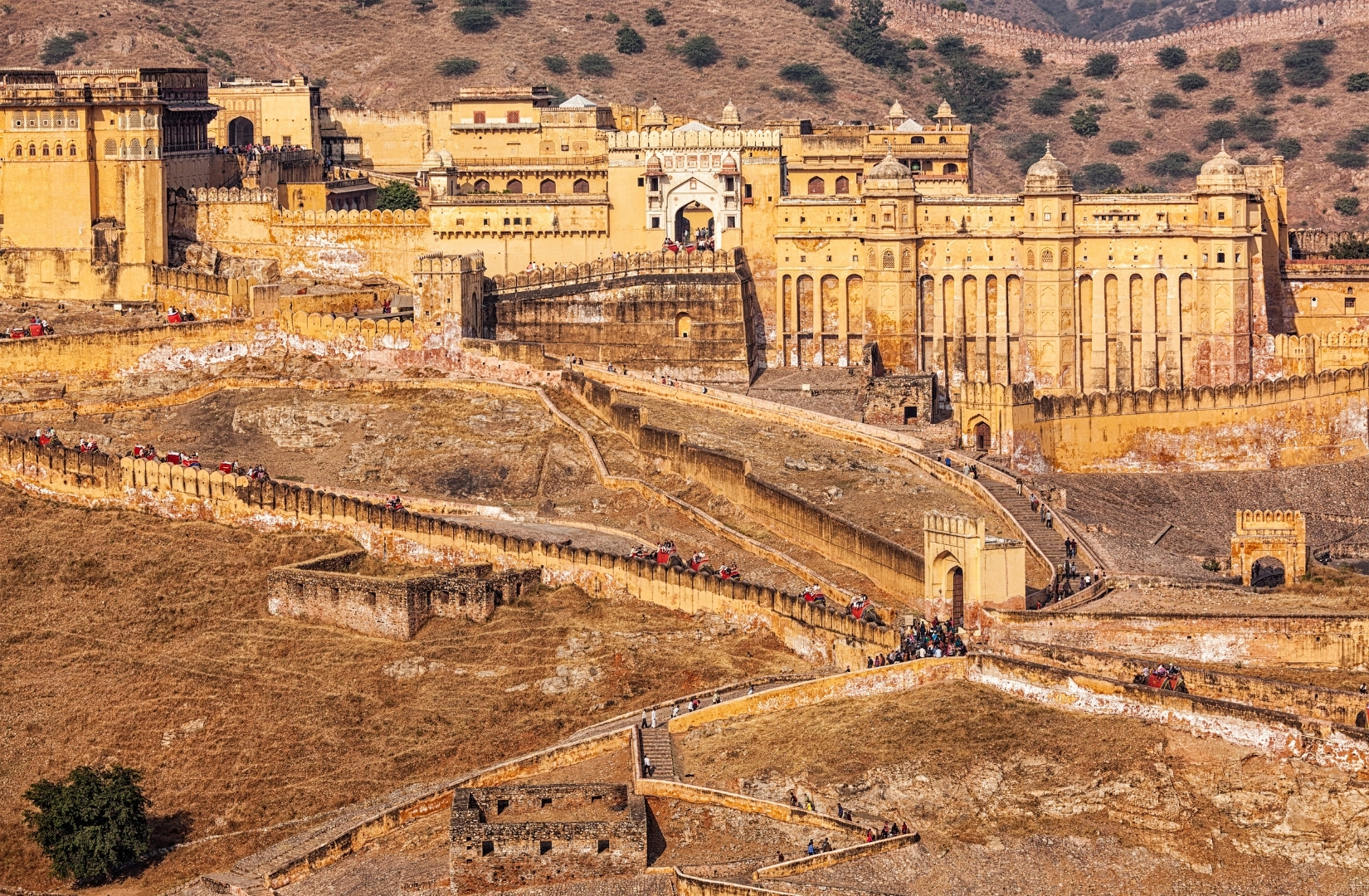 The ramparts of Amber Fort climbing the ridge above Maota Lake outside Jaipur in afternoon light