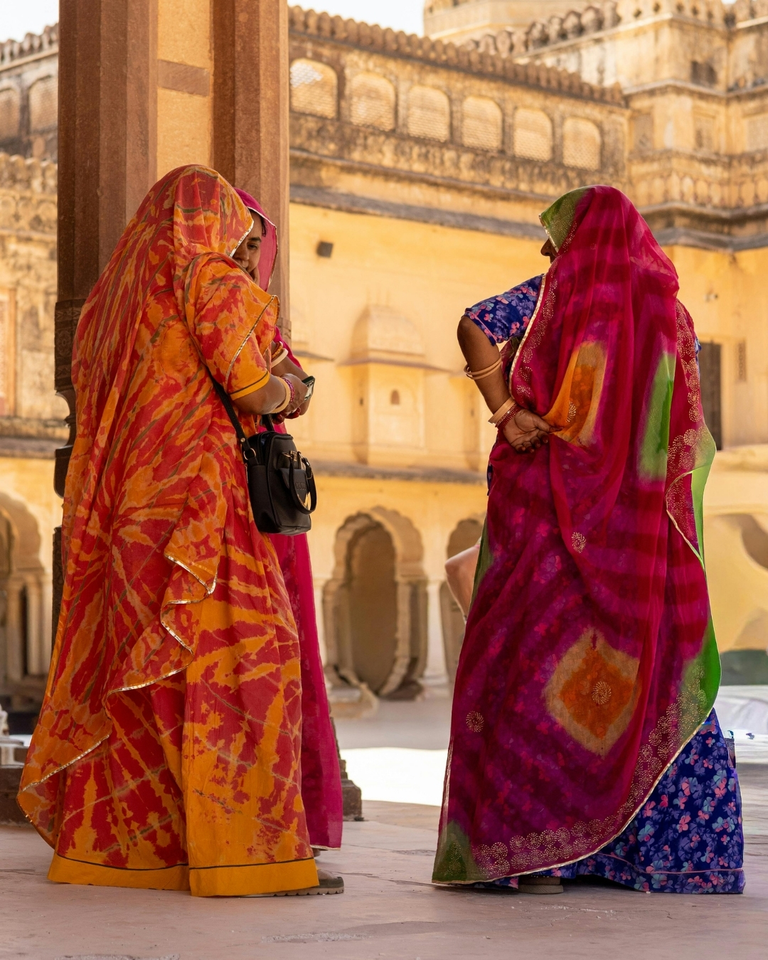Women in saris walking through Amber Fort, Jaipur.