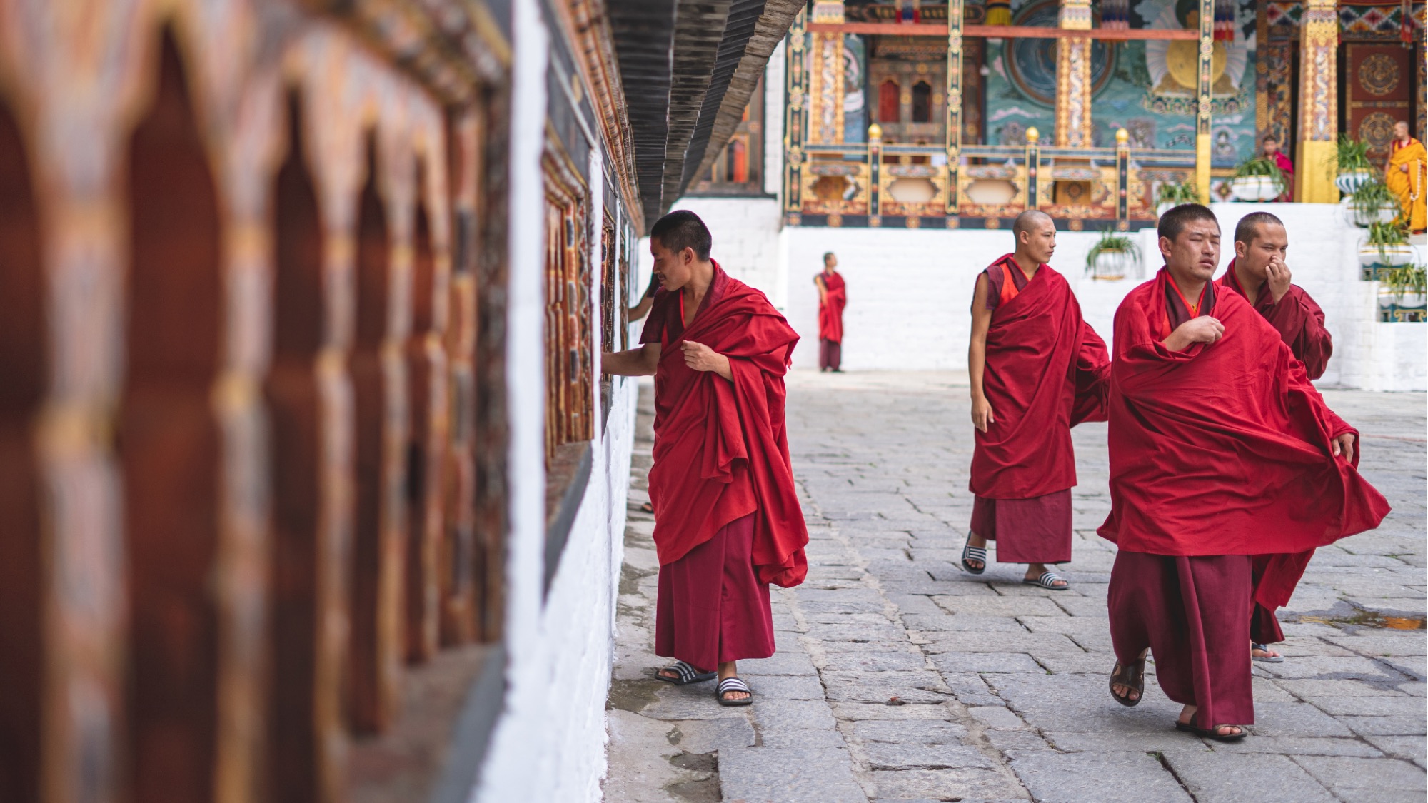 Monks walking through a monastery courtyard in Bhutan.